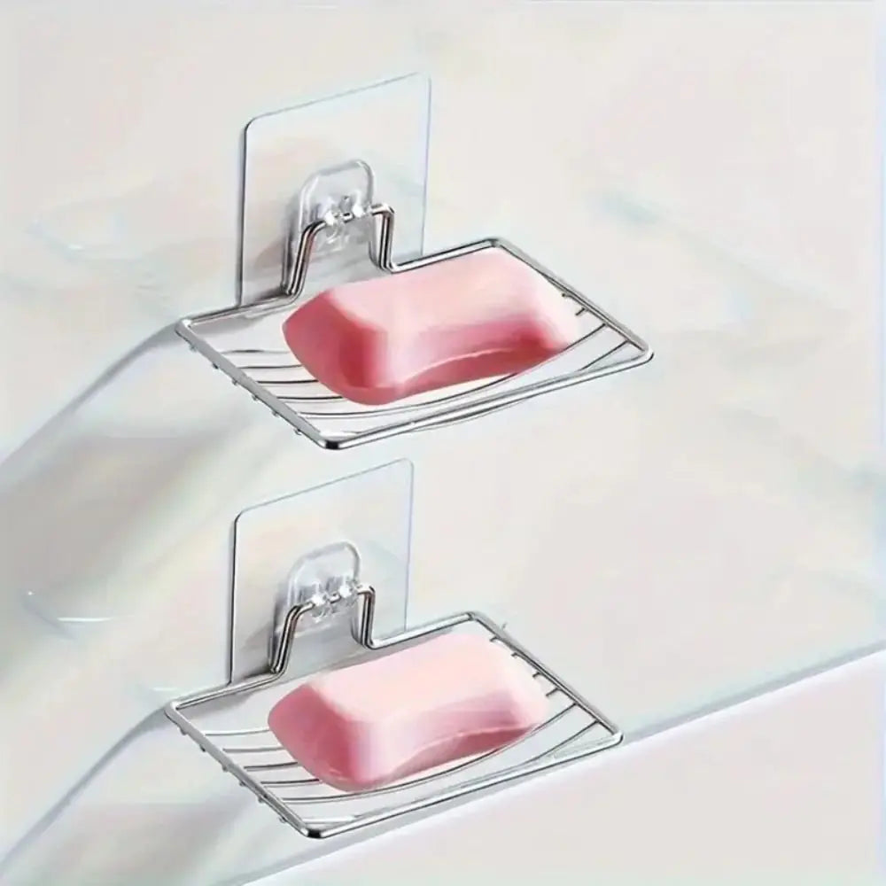 Two Stainless steel wall mounted soap dish holders with self adhesive backing with pink soap bars on a light background