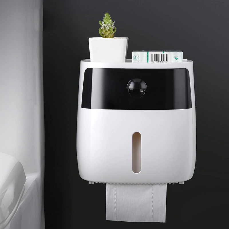 White & Black wall mounted waterproof toilet paper holder with storage drawer with a plant on top against a black background.