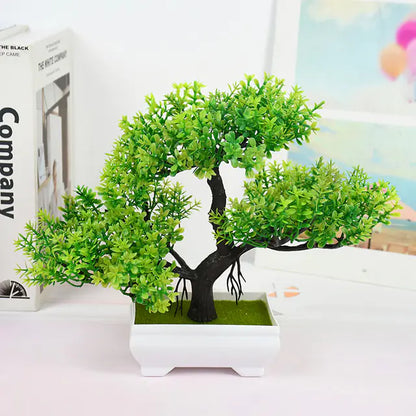 Artificial bonsai tree in a white pot on a table with a blurred background