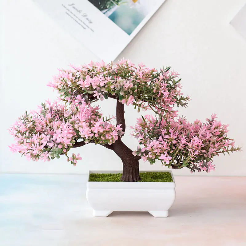 Artificial bonsai tree with pink flowers in a white pot on a light background