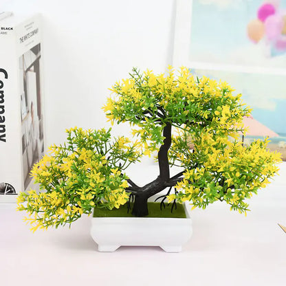 Artificial bonsai tree with yellow leaves on a white surface