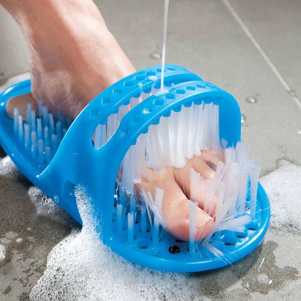 Blue foot scrubber with a foot inside, being used to scrub feet in a soapy water.