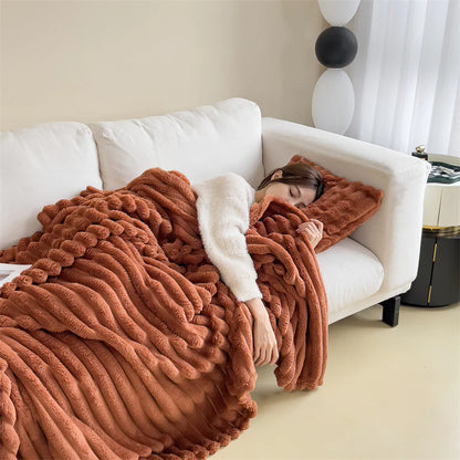 Brown cosy ribbed fleece throw blanket in neutral colour draped over couch, soft textured warm blanket for home comfort and relaxation.