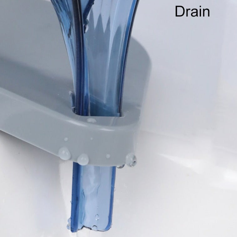 Close up of a drain with clear water flowing through it on a white background.
