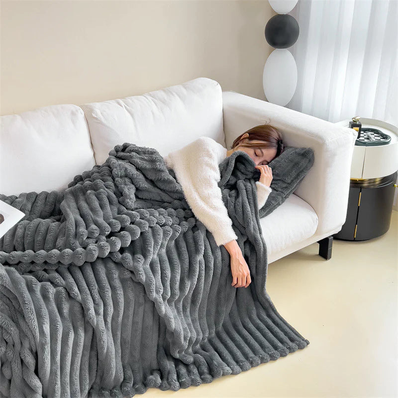 Dark Grey cosy ribbed fleece throw blanket in neutral colour draped over couch, soft textured warm blanket for home comfort and relaxation.