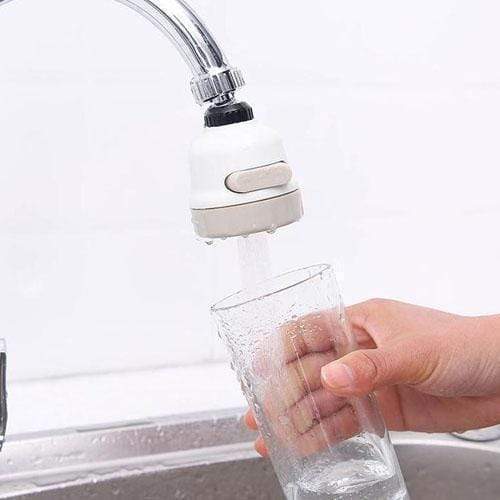 Faucet with a water filter attachment being used to fill a glass.