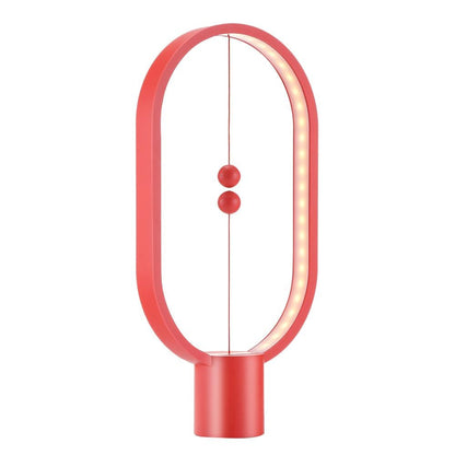 Red Modern LED magnetic table lamp with suspended magnetic sphere switch creating ambient warm lighting on a white background