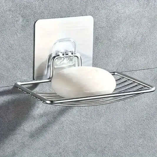 Stainless steel wall mounted soap dish holder with self adhesive backing for bathroom and kitchen with a bar of soap on a grey wall