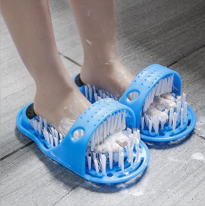 Two blue foot massager bath slippers with soft bristle brushes on feet on a tiled floor.