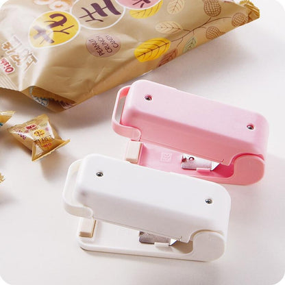 Two colourful Mini heat bag sealer device on a light background with a package of snacks.