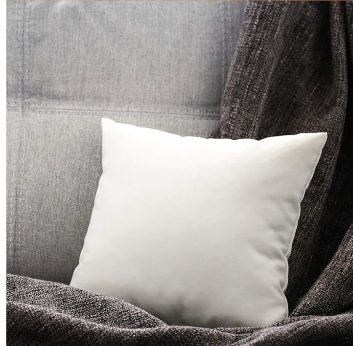 Ultra soft white cushion insert with high elastic PP cotton filling and brushed fabric cover for superior comfort and support on a grey couch with a grey blanket