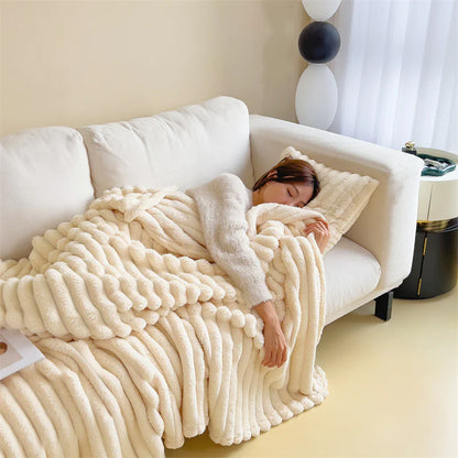 White cosy ribbed fleece throw blanket in neutral colour draped over couch, soft textured warm blanket for home comfort and relaxation.